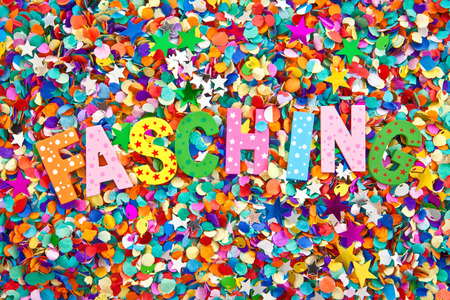 Fasching inin colorful wooden characters on background made of confettiの写真素材