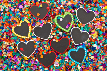Little chalkboard hearts on a background of confettiの写真素材