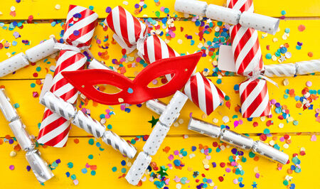 Colorful party crackers and confetti on yellowの写真素材