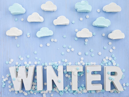 Marshmallows in cloud shapes and snowflake sprinkles on blue backgroundの写真素材