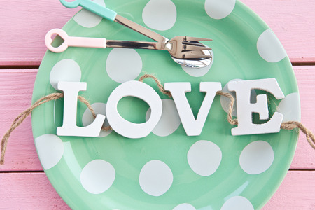 Green plate with polka dots on rustic wooden boardsの写真素材