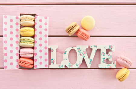Variety of french macarons on pink wooden boardsの写真素材