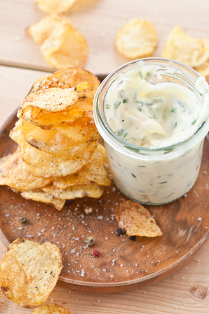 Homemade potato chips with a glass of mayonaise dipの写真素材