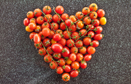 Colorful ripe tomatoes on background of dark marbleの写真素材