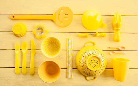 Colorful kitchen untensils in bright yellow on yellowの写真素材