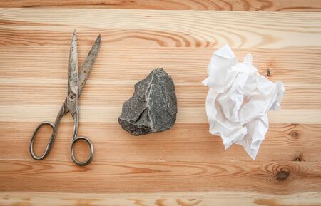 Rock, paper, scissors on rustic wooden background