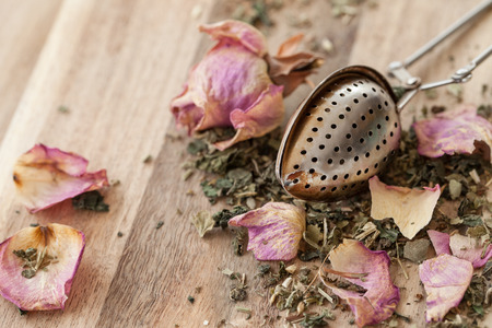 Green tea with pink rose petals with vintage tea spoonの写真素材