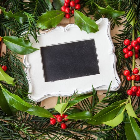 Rustic christmas background with holly and pine branches