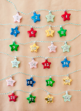 24 shiny stars in various color on brown paperの写真素材
