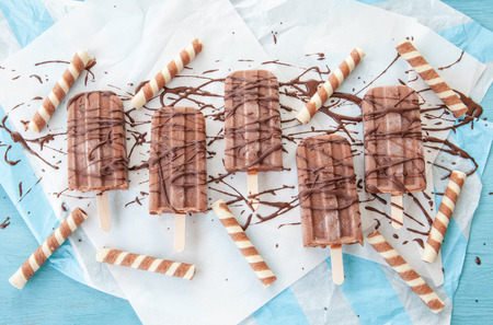 Homemade frozen popsicles with chocolate on paperの写真素材