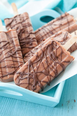 Homemade frozen popsicles with chocolate on paperの写真素材