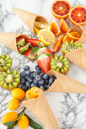 Ice cream waffle cones with fresh ripe fruitsの写真素材