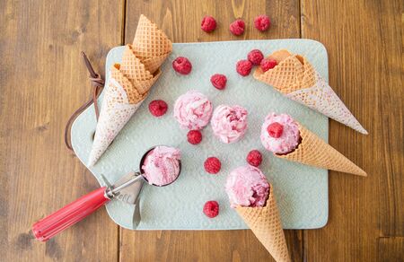 Scoops of raspberry ice cream and waffle cones