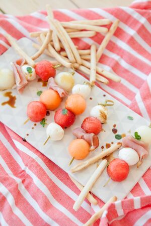Fresh cantaloupe melon with mozzarella balls and smoked hamの写真素材