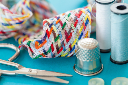 Colorful sewing kit with yarn and scissors on blueの写真素材