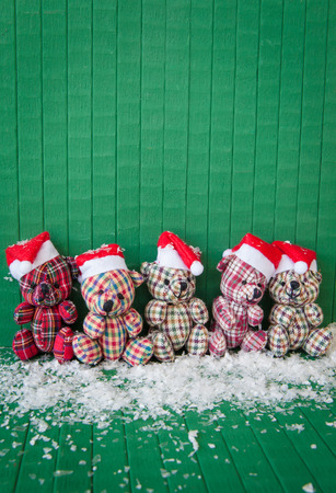 Little teddybears with red Santa Claus hats on Greenの写真素材