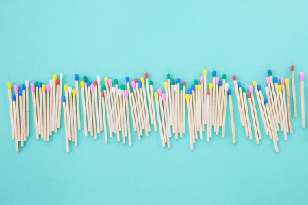 Wooden matches in pastel colors on blueの写真素材