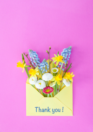 Little bouquet of spring flowers in little yellow envelopeの写真素材