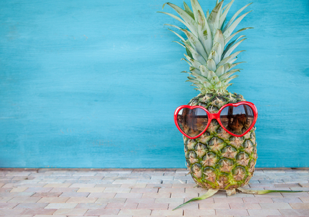 Pineapple with funny heart sunglasses, vacation concept