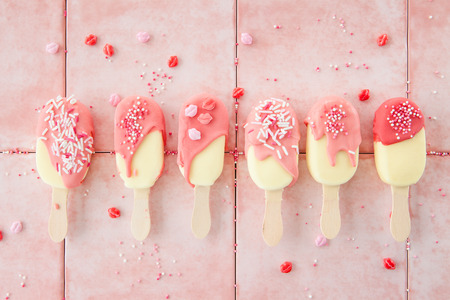 Chocolate covered Vanilla ice cream pops with sugar sprinklesの写真素材