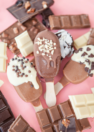 Chocolate dipped vanilla ice cream with nuts and sprinklesの写真素材
