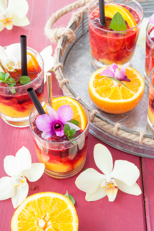 Colorful cocktail with fresh fruits and colorful orchidsの写真素材