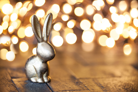 Little golden easter bunny in front of unfocused lights