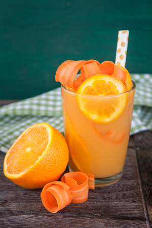 Glass orange carrot juice with a paper strawの写真素材