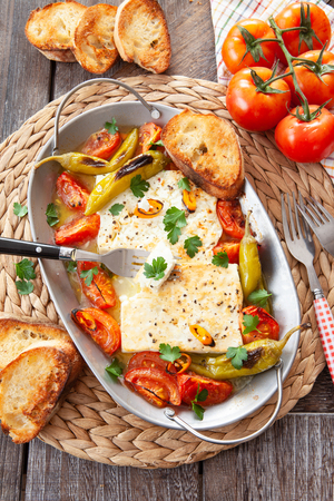 Gratinated feta cheese with tomatoes and chillisの写真素材