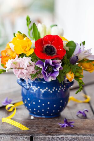 Bunch of colorful spring flowers in a little vase