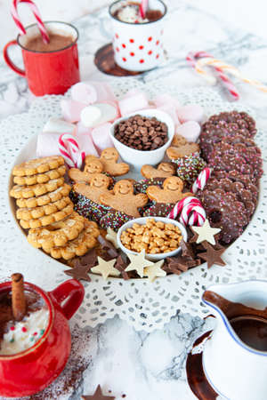 Hot chocolate with a plate of toppings and cookiesの写真素材