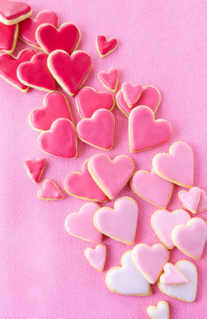Little cookie hearts with pink icing on a pink backgroundの写真素材