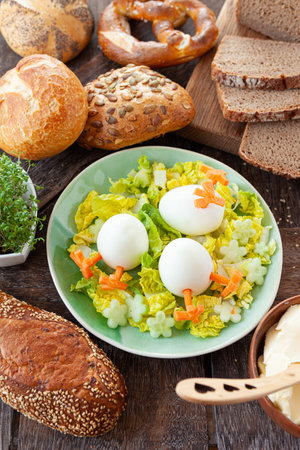 Easter breakfast with hard boiled eggs and bread rollsの写真素材