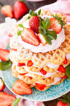 Waffles stacked with whipped cream and fresh strawberriesの写真素材