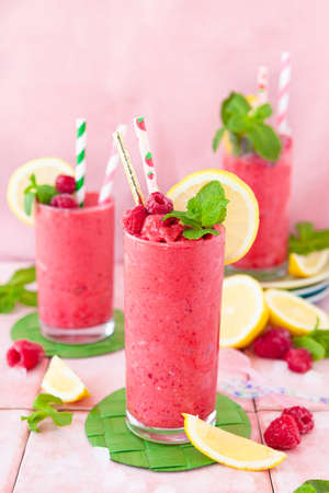 Frozen Smoothie, raspberry sherbet in glasses with fresh lemon and mintの写真素材