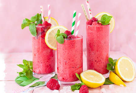 Frozen Smoothie, raspberry sherbet in glasses with fresh lemon and mint