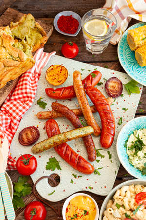BBQ with grilled sausages, pasta salad and homemade breadの写真素材