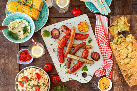 BBQ with grilled sausages, pasta salad and homemade breadの写真素材