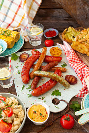 BBQ with grilled sausages, pasta salad and homemade breadの写真素材
