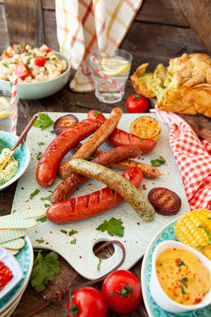 BBQ with grilled sausages, pasta salad and homemade breadの写真素材