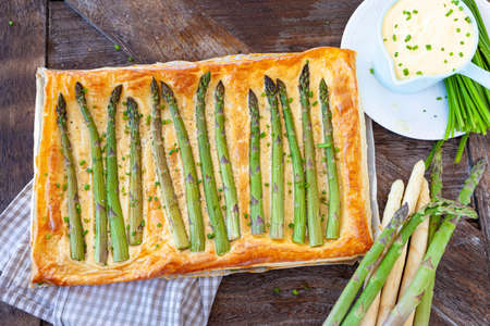 Savory puff pastry quiche with green asparagusの写真素材