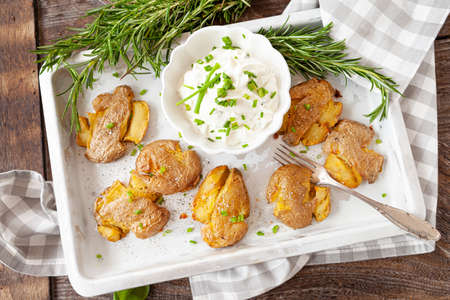 Smashed potatoes, crisp baked potatoes with fresh rosemaryの写真素材