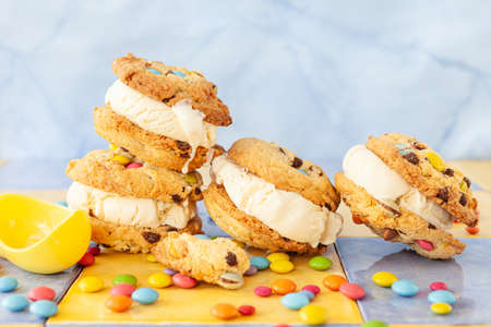 Vanilla ice cream sandwich with chocolate chip cookies and colorful chocolate lentilsの写真素材