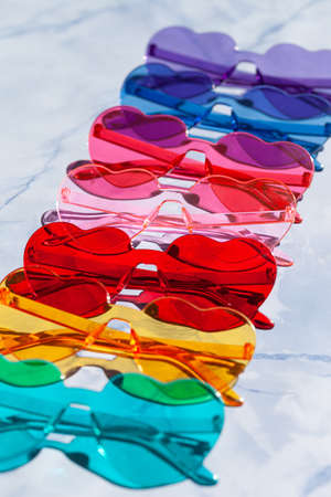Colorful sunglasses in heart shaped on a blue backgroundの写真素材