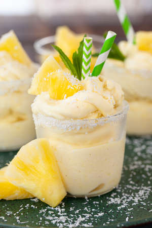 Delicious pineapple soft serve with coconut flakes and mint leavesの写真素材