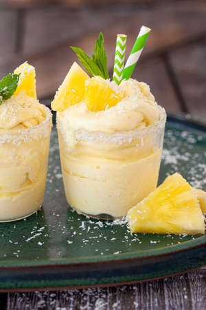 Delicious pineapple soft serve with coconut flakes and mint leavesの写真素材
