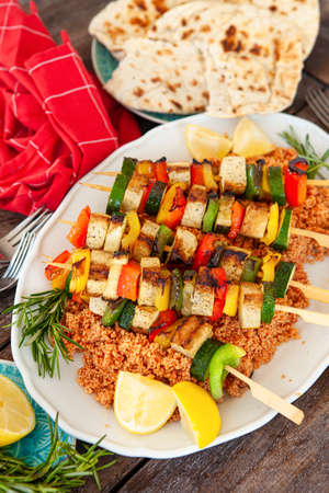 Grilled vegetable skewers with soy on tomato couscousの写真素材