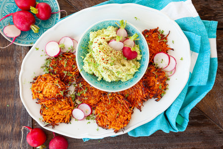 Savory sweet potato fritters with avocado dip and fresh radishの写真素材