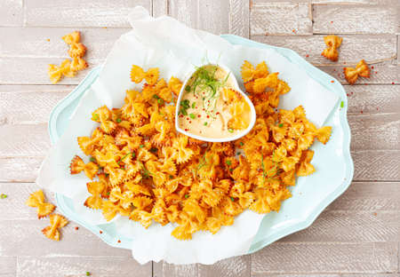 Spicy farfalle pasta chips with homemade herb dipの写真素材