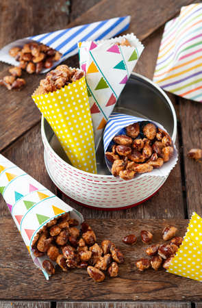 Sugar roasted almonds with cinnamon in little colorful paper bagsの写真素材